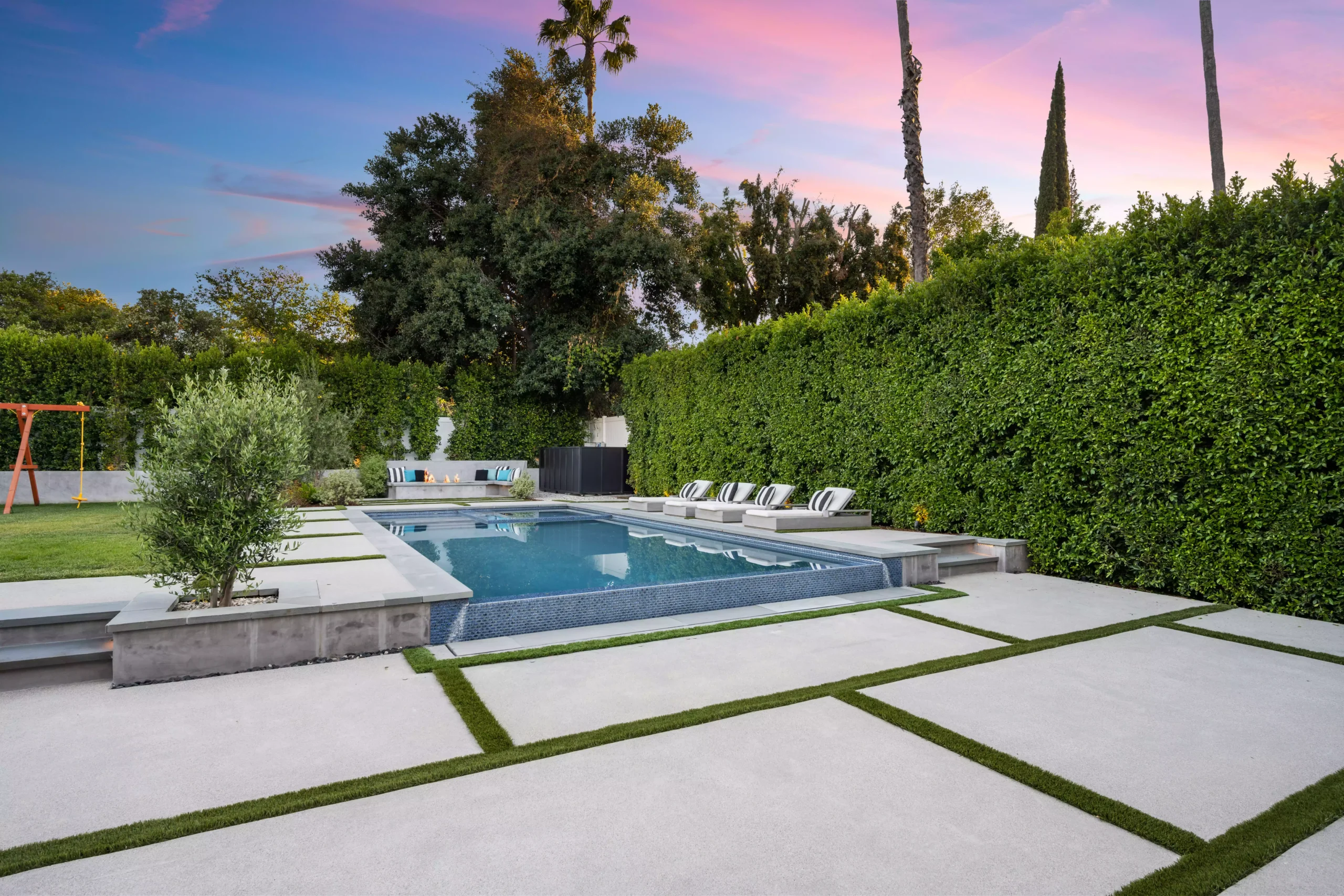 a-small-swimming-pool-sits-between-some-hedges-wit-2024-04-22-17-15-30-utc